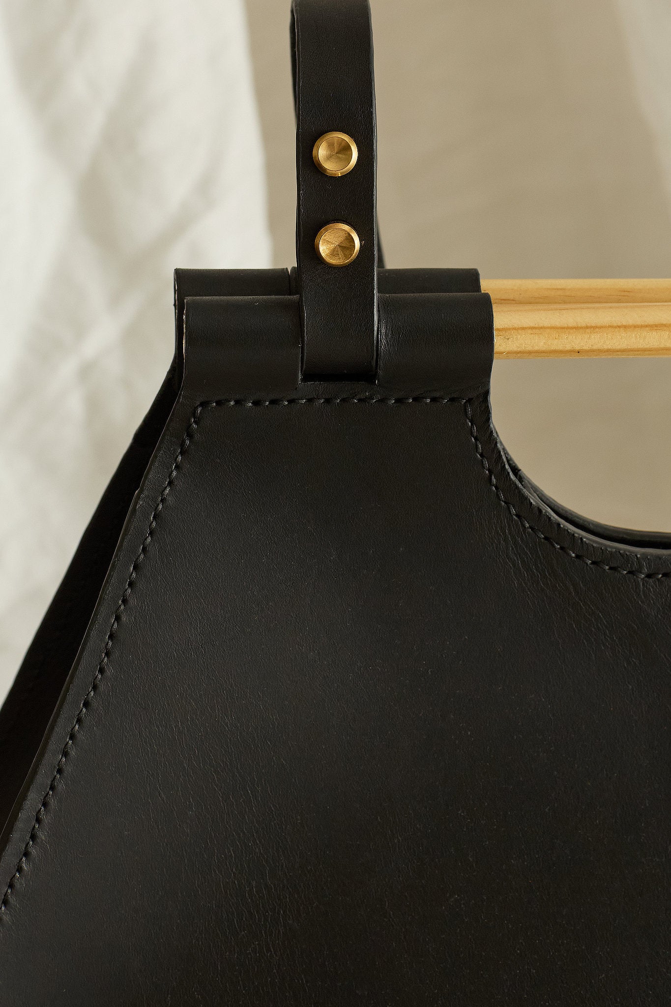 Close up of the Ophelia leather tote bag in black focused on hand-stitch details
