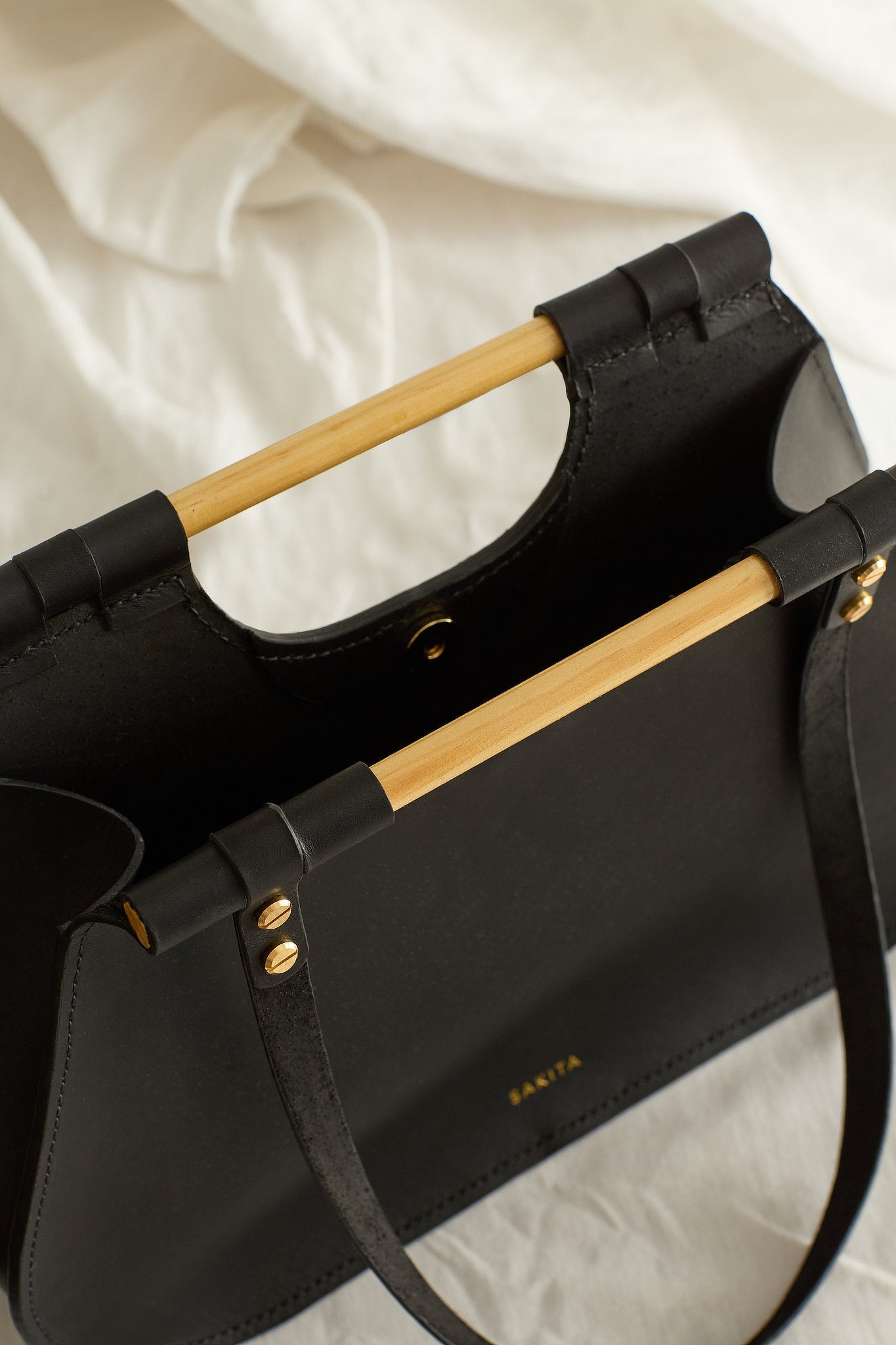 Aerial view of the Ophelia leather tote bag in black showing the raw unlined interior