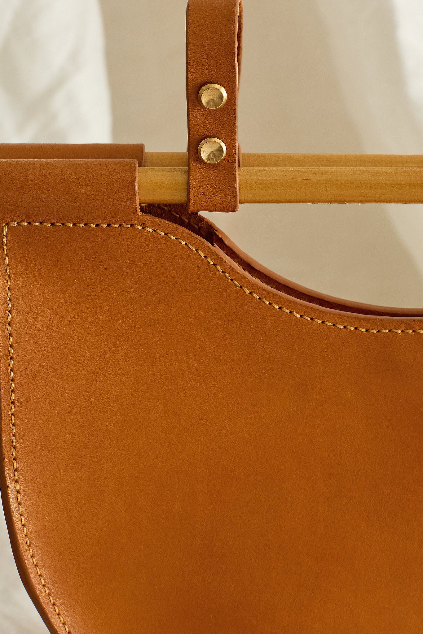 Close up of the Celine leather bag in tan with stitching details, wood and brass