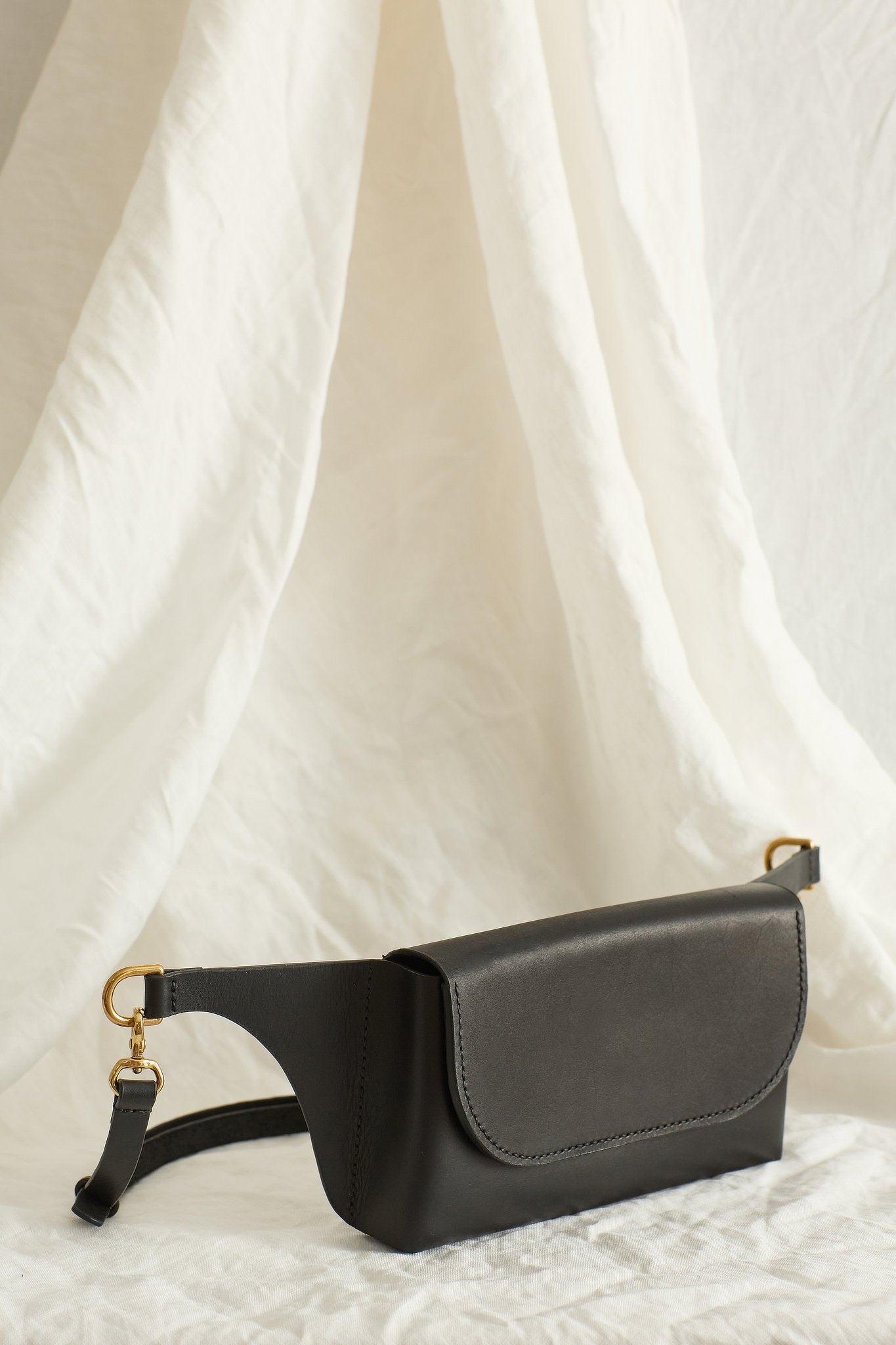 Angled view of the Effie leather belt bag in black