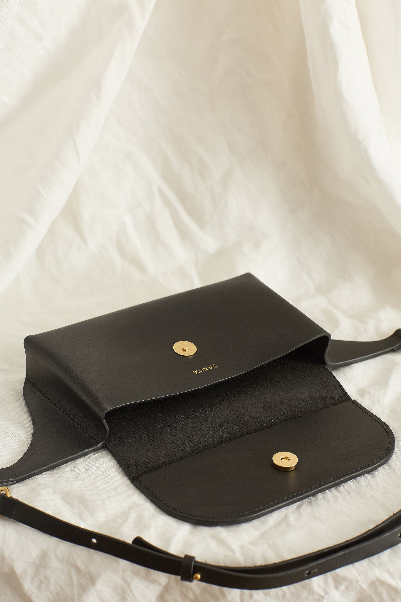 Aerial view of the Effie leather belt bag in black showing the raw interior