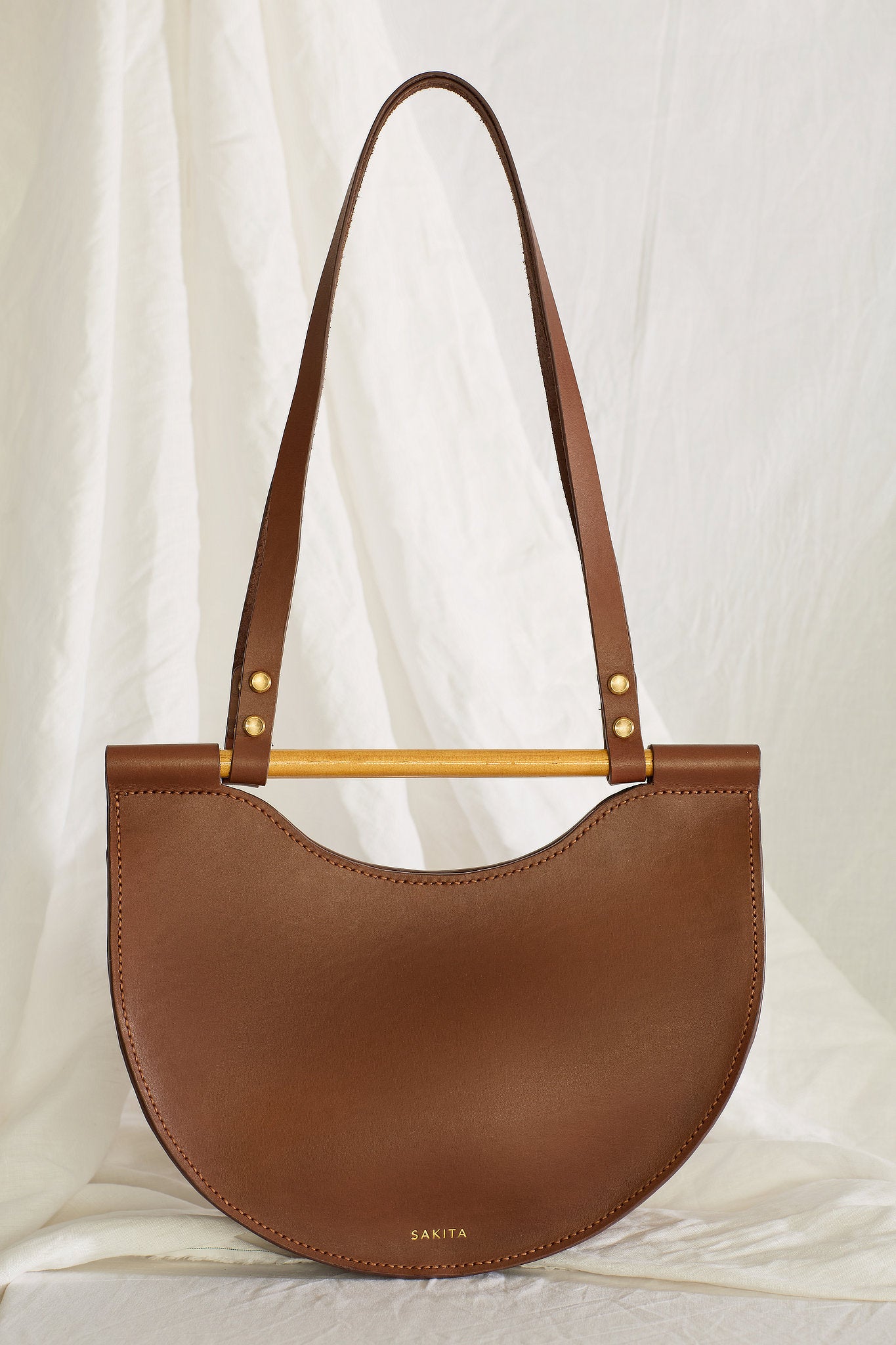 Front view of the Celine half moon leather bag in brown